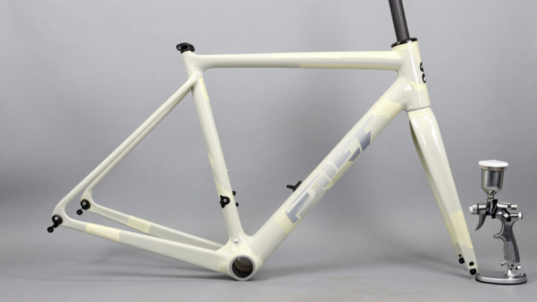 Cuadro de bicicleta en cabina de pintura con zonas enmascaradas